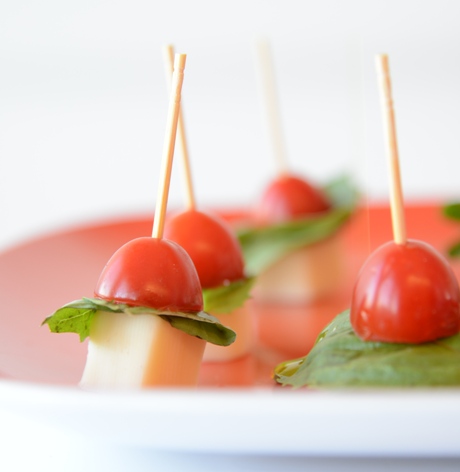 Tomato, basil, and vegan mozzarella caprese hors d'oeuvres. Made with Follow Your Heart cheese.