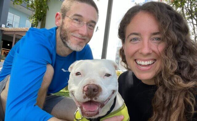 Dan and Angel and Katherine, pictured from left to right; Angel was rescued by CAP fieldworkers after spending years chained and penned outside 24/7 in rural North Carolina, and she was the first PETA foster animal who Dan and Katherine cared for together.