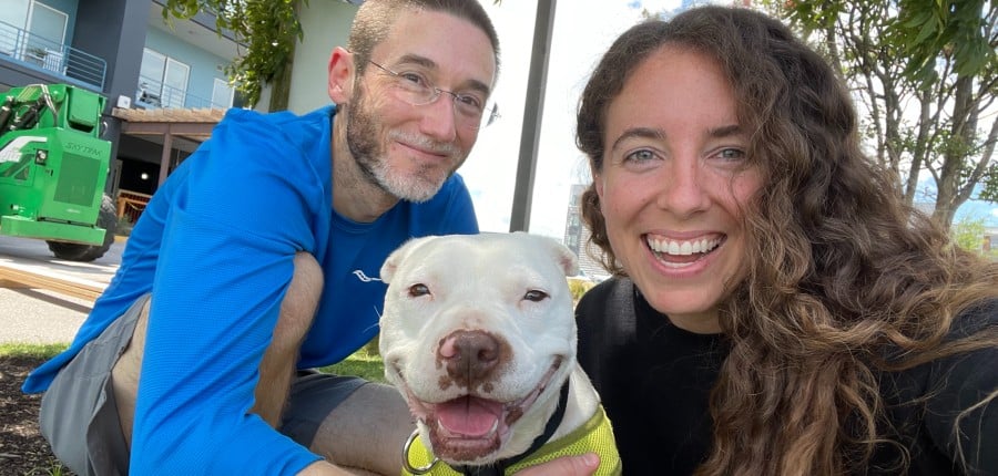 Dan and Angel and Katherine, pictured from left to right; Angel was rescued by CAP fieldworkers after spending years chained and penned outside 24/7 in rural North Carolina, and she was the first PETA foster animal who Dan and Katherine cared for together.