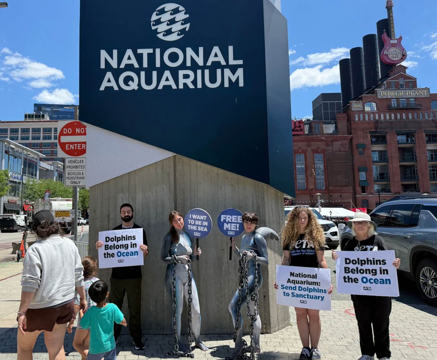 PETA supporters holding signs demanding that the National Aquarium send dolphins to sanctuary